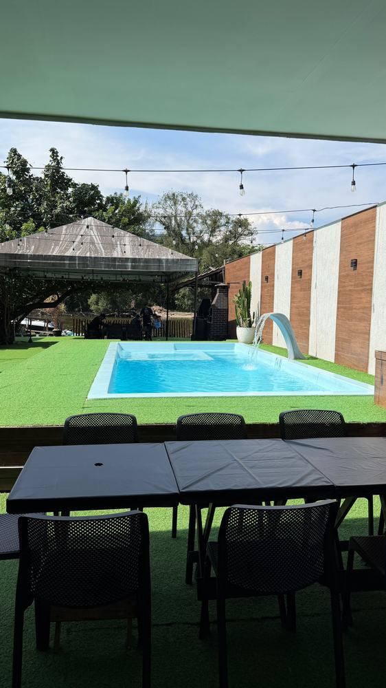 Área de lazer com mesas na sombra